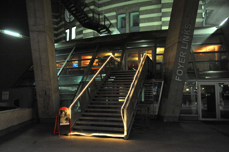 Beleuchteter Treppenaufgang zum Foyer der Raiffeisen Halle bei Nacht